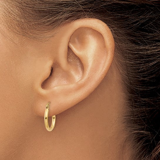 15 mm slim huggie hoop earrings in solid 14K yellow gold shown on ear