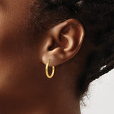 17 mm slim huggie hoop earrings in solid 14K yellow gold shown on ear