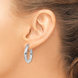 25 mm bold hoop earrings in solid 14K white gold shown on ear