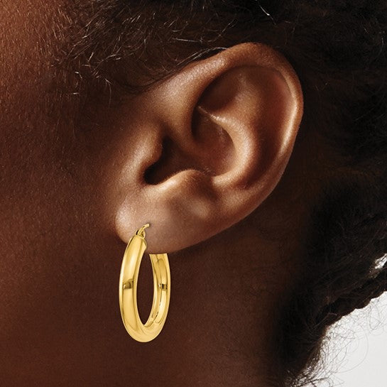 25 mm bold hoop earrings in solid 14K yellow gold shown on ear