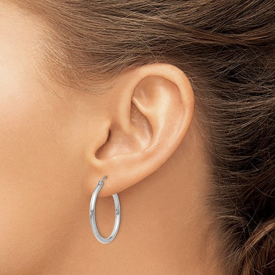 25 mm slim hoop earrings in solid 14K white gold shown on ear