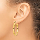 35 mm bold hoop earrings in solid 14K yellow gold shown on ear
