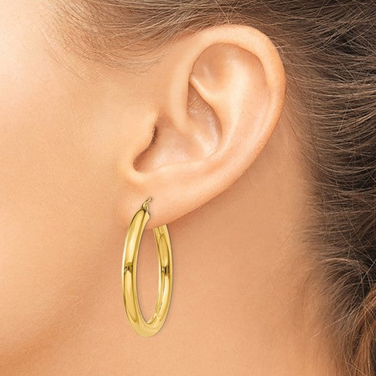 35 mm bold hoop earrings in solid 14K yellow gold shown on ear