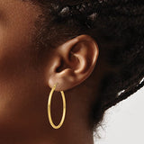 35 mm slim hoop earrings in solid 14K yellow gold shown on ear