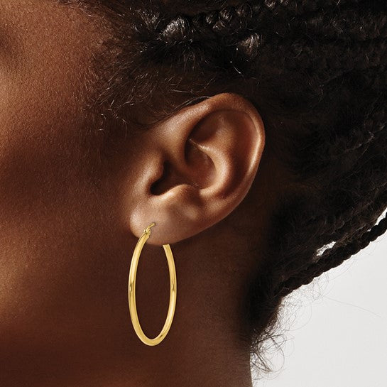 35 mm slim hoop earrings in solid 14K yellow gold shown on ear