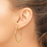 40 mm slim hoop earrings in solid 14K yellow gold shown on ear